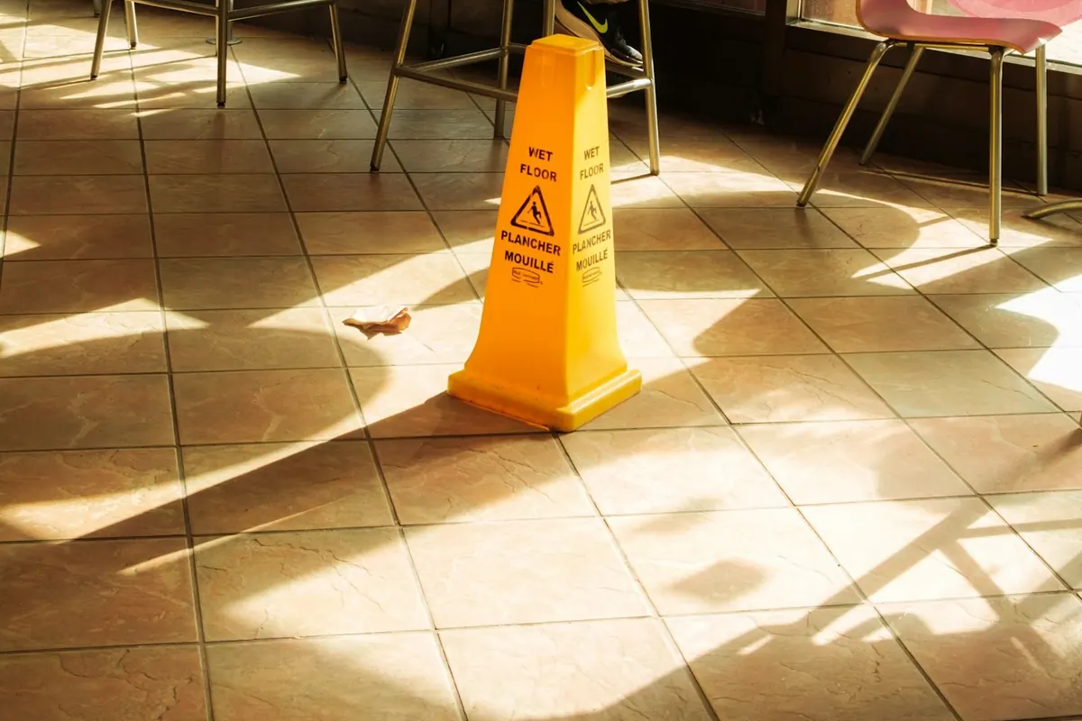 A wet floor warning cone on a tile floor